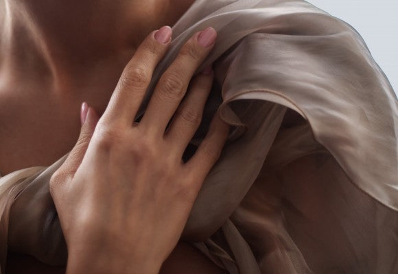 mujer envuelta en gasa rosa momento de autocuidado