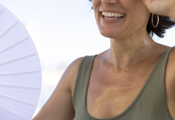 Mujer sonriente sosteniendo un abanico blanco