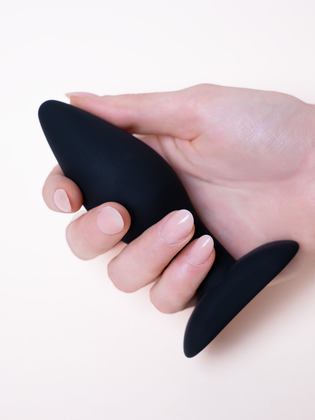 Plug anal negro sostenido en la mano
