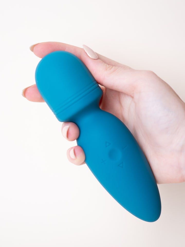 Masajeador Soft Wand turquesa sostenido en la mano