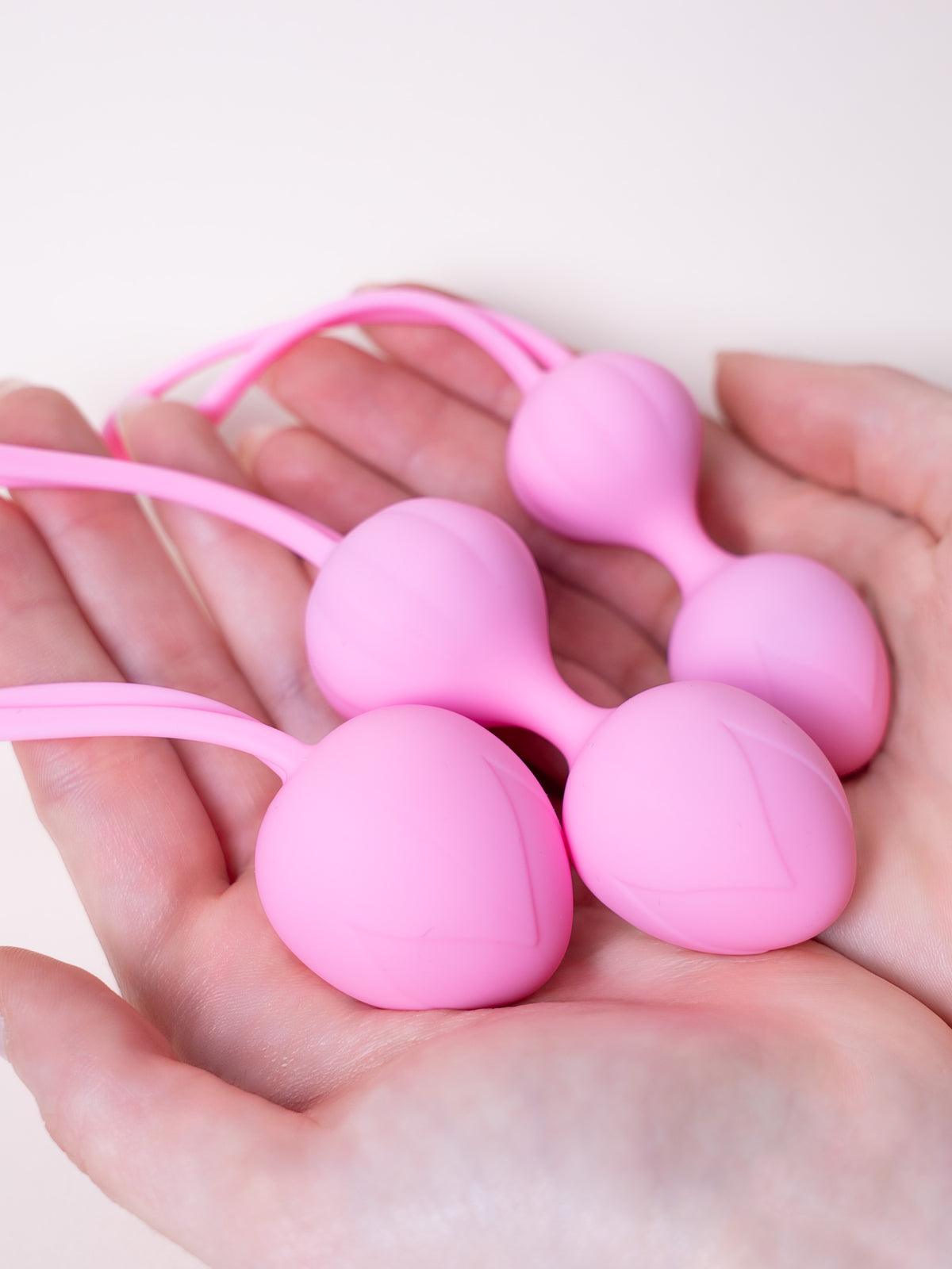 Trio Kegel, tres bolas de silicona médica rosa en la  mano